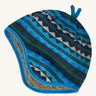 A blue reversible beanie with diamond patterns on a cream background