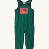 Green baby overalls on a cream background