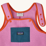A close up of poppers on the overalls