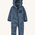 Dark blue fluffy kids all in one with little ears on the hood on a cream background
