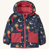 Navy Patagonia reversible jacket with a moon and stars design and red pockets on a cream background