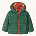 Green Patagonia reversible jacket with a abstract design on the hood on a cream background
