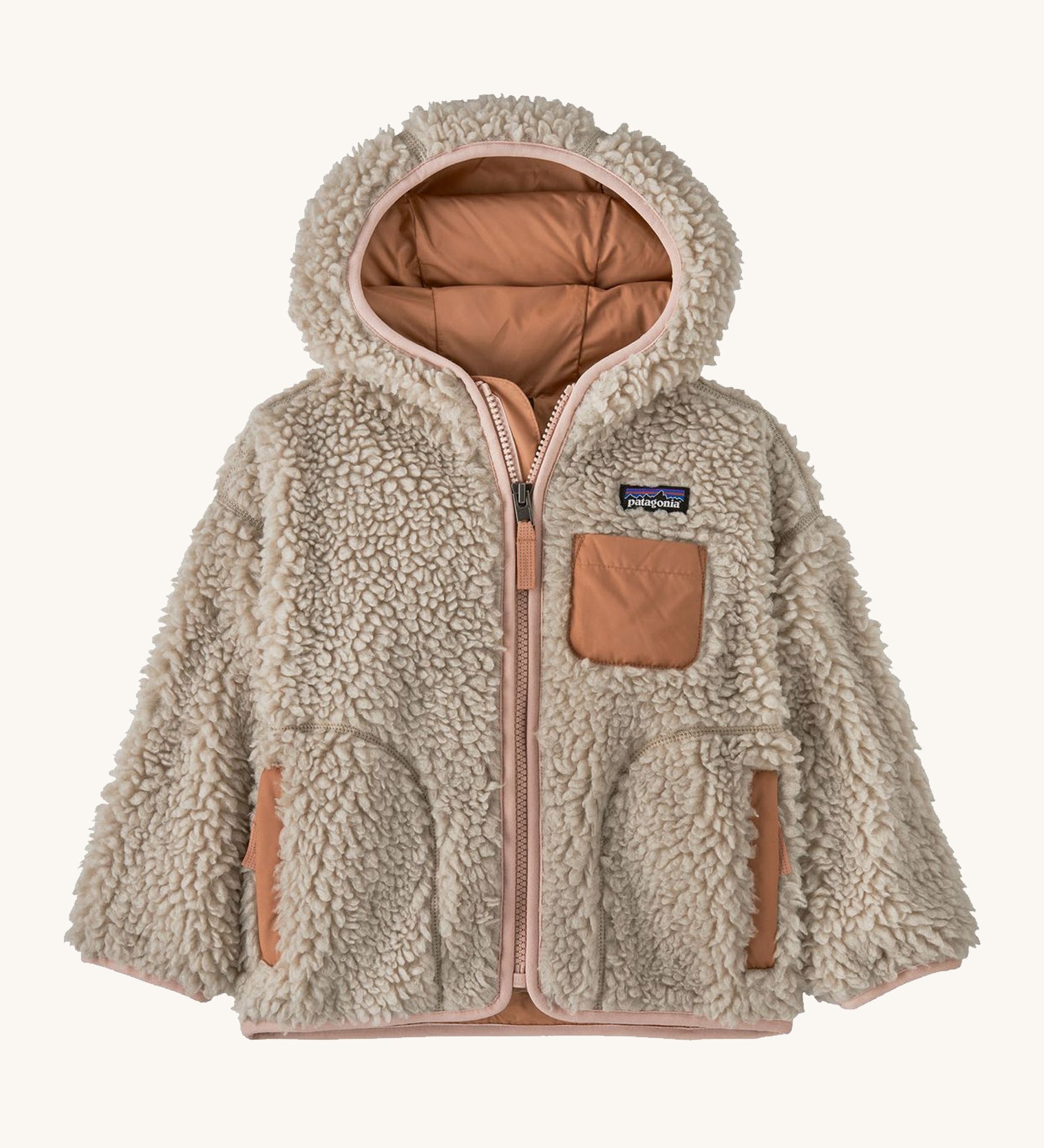 Natural kids Patagonia fleece with a light pink trim on a cream background