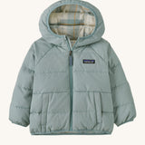 A light blue hooded jacket with a check design on the inside on a cream background