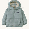 A light blue hooded jacket with a check design on the inside on a cream background