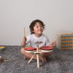 Overhead view of the Plan Toys Musical Band Children's Drum Kit being played by a toddler