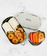 A top down image of the A slice of green oval lunchbox with mini container showing various food items in each container