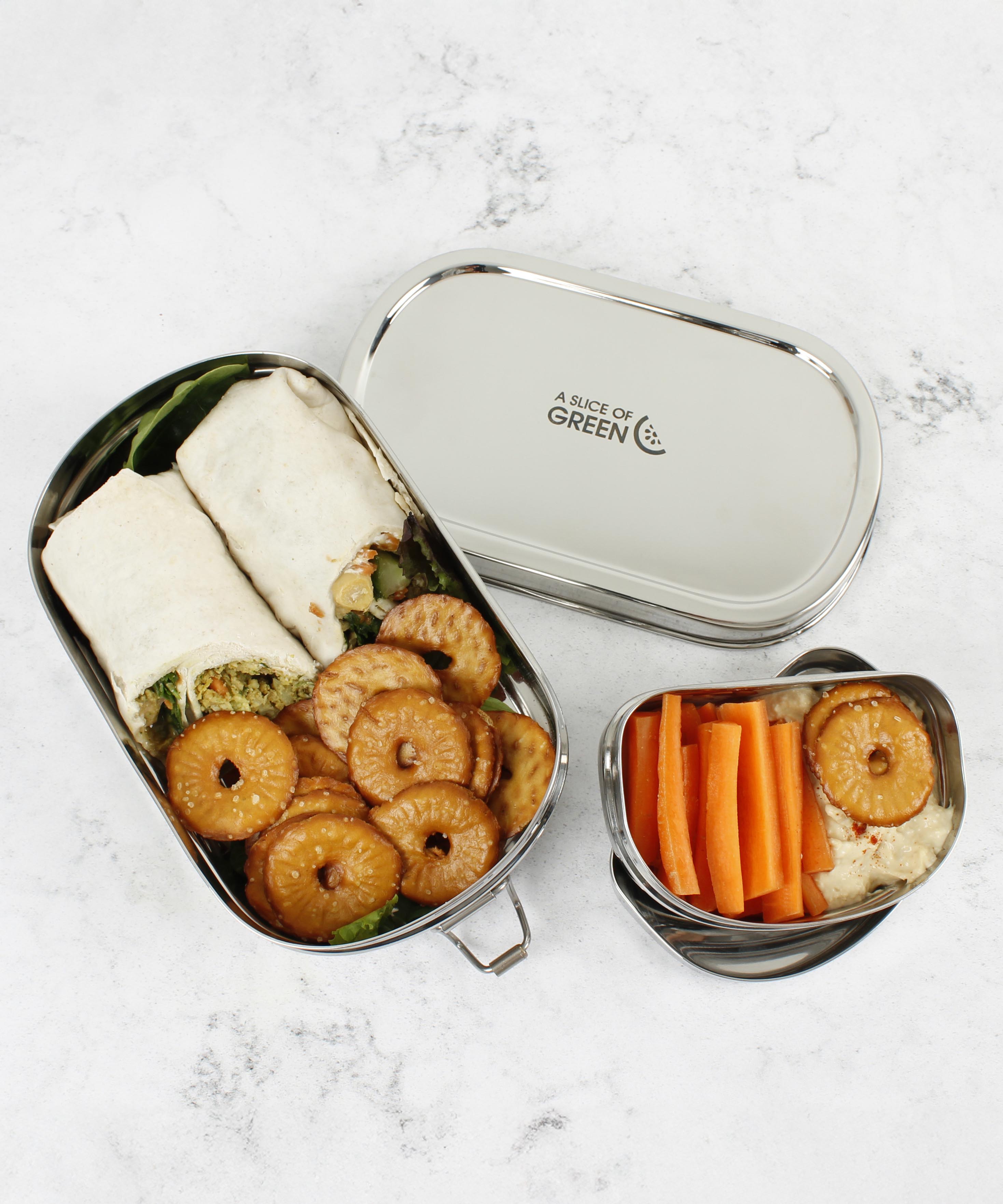 A top down image of the A slice of green oval lunchbox with mini container showing various food items in each container