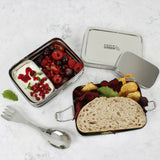 A top down image of A slice of green two tier lunchbox with mini container showing various food and fruit items inside each compartment