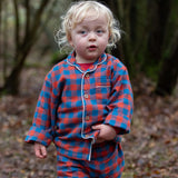 Child wearing the Little Green Radicals burnt ochre check classic pyjamas.
