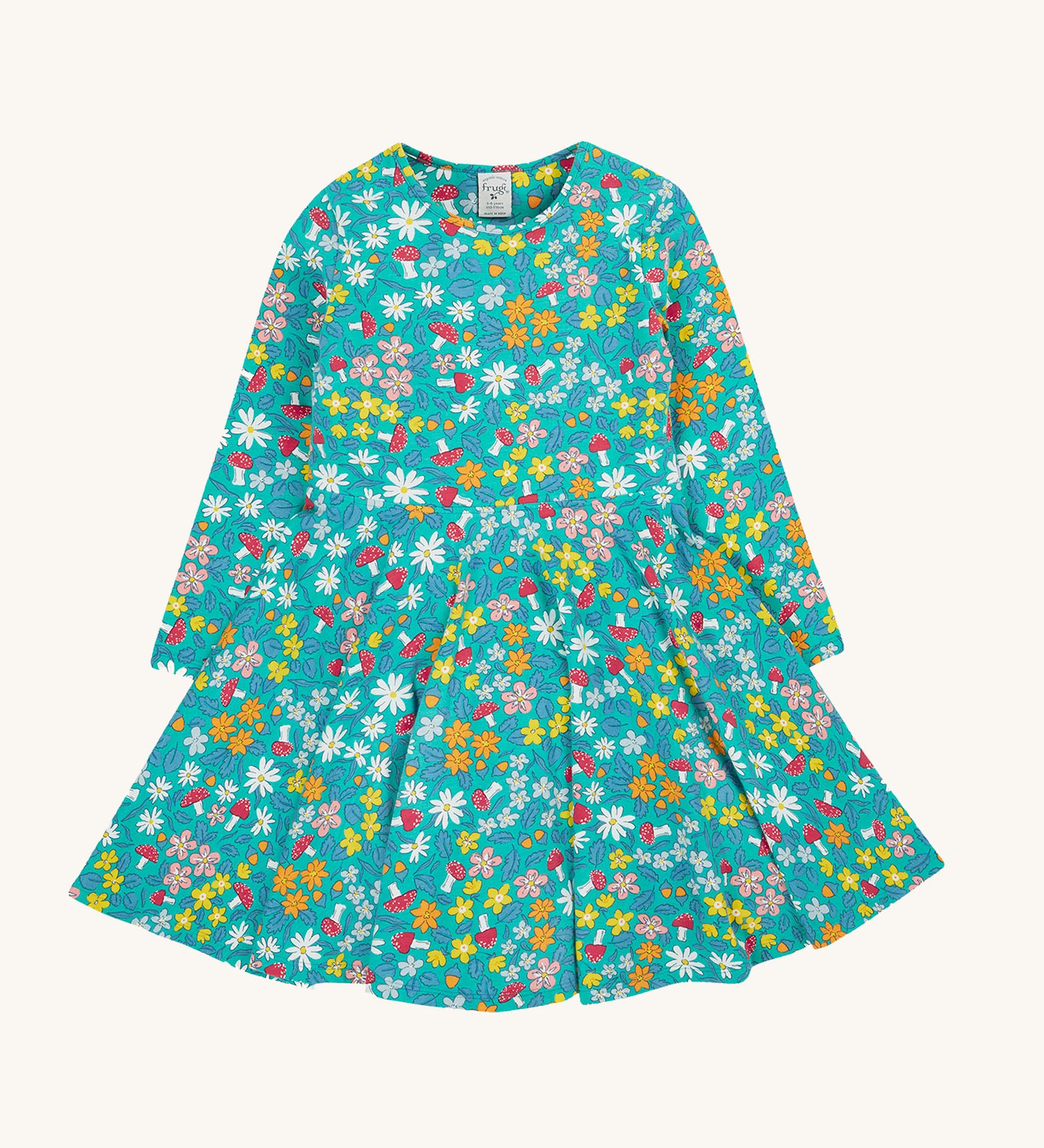 The Frugi Sofia skater dress with a wild woods print design on a green background. The print features flowers and toadstools.