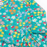 A close up of the Frugi Sofia skater dress with a wild woods print design on a green background. The print features flowers and toadstools.