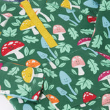 A close up view on the Frugi fun-guys snuggle fleece. A mushroom themed print on a green coloured background. 