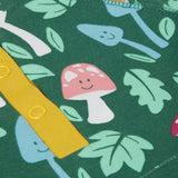 A super zoomed in close up of the Frugi fun-guys snuggle fleece. A multi-coloured mushroom themed print on a green coloured background. 