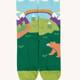 The bbear design organic cotton kids socks from the Frugi rock my socks adventure socks multi-pack. The design features a brown bear in a woodland setting with snow topped mountains in the background.