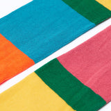 A close up of the colour block, hotchpotch design Frugi Norah children's tights.