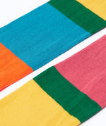 A close up of the colour block, hotchpotch design Frugi Norah children's tights.