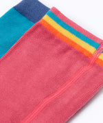 A close up of the waistband details on the tights in the Frugi Norah 2 pack. The rose pink tights have a multi-coloured striped design waistband and the hotchpotch design has a solid navy blue colour waistband.