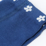 A close up of the waist band on the Frugi Norah navy blue Flowers design footed tights. A navy waist band with little white flowers all around. 