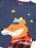 Close up of the fox applique on the long sleeved top from the Frugi organic cotton caden check festive fox pyjamas. The fox is wearing a blue bobble hat and a check shirt.