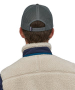 A person wearing the Patagonia P-6 Logo Trucker Hat - Forge Grey, showing the back of the hat on their head