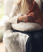 Avery Row Nursing Pillow - Coastline, a mother breastfeeding her baby with a brown muslin cover.