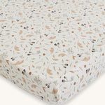 Avery Row Cotbed Fitted Sheet - Grasslands. A light cream fitted sheet with delicate grassland print