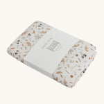 Avery Row Cotbed Fitted Sheet - Grasslands, folded on a plain background