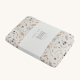 Avery Row Cotbed Fitted Sheet - Grasslands, folded on a plain background