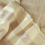 Avery Row Stripe Knit Organic Baby Blanket - Oat Melange, closer details of the knitted stripe pattern and scalloped edge. 