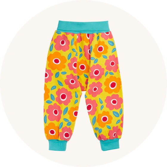 Frugi Parsnip baggy Pants in yellow and pink floral print with blue cuffs and waistband, made from organic cotton, to represent baby bottoms and trousers at Babipur.