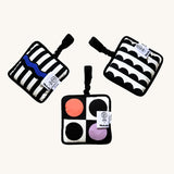 3 of the Etta Loves x Camille Walala Sensory Hanging Squares. The left square has black and white stripes, with a royal blue wavy line running through the middles. The middles square has a lilac and orange circle with monochromatic , black and white circles. The right square has black semi circles on a white fabric background.