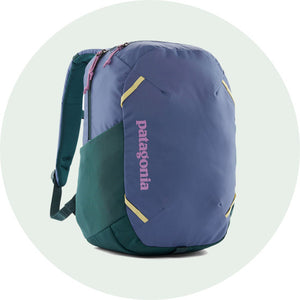 Patagonia Atom Day Backpack 24L in Current Blue/purple with a teal side bottle pocket and lilac Patagonia logo down the front to represent bags, packs and gear for sale at Babipur. 