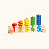 Bajo pull along stacker showing 5 wooden pegs on a base with wheels and coloured ring pieces 
