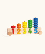 Bajo pull along stacker showing 5 wooden pegs on a base with wheels and coloured ring pieces 
