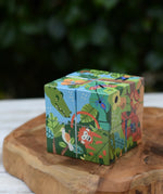 Bajo 2-in-1 polar jungle wooden cube block puzzle placed on a wooden surface shown on the jungle design side.