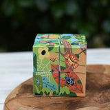 Bajo 2-in-1 polar jungle wooden cube block puzzle placed on a wooden surface shown on the jungle side with leaves and bugs.