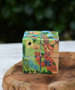Bajo 2-in-1 polar jungle wooden cube block puzzle placed on a wooden surface shown on the jungle side with leaves and bugs.