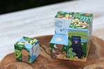 Bajo 2-in-1 polar jungle wooden cube block puzzle placed on a wooden surface with one block taken out of the cube.