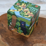 Bajo 2-in-1 polar jungle wooden cube block puzzle placed on a wooden surface shown on the jungle side with a jaguar on one side and a snake on the other.