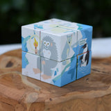 Bajo 2-in-1 polar jungle wooden cube block puzzle placed on a wooden surface shown on the polar design side featuring a yeti.