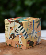 Bajo 2-in-1 reef desert wooden cube block puzzle shown on the desert design side placed on a wooden surface. 