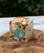 Bajo 2-in-1 reef desert wooden cube block puzzle shown on the desert design side placed on a wooden surface. 