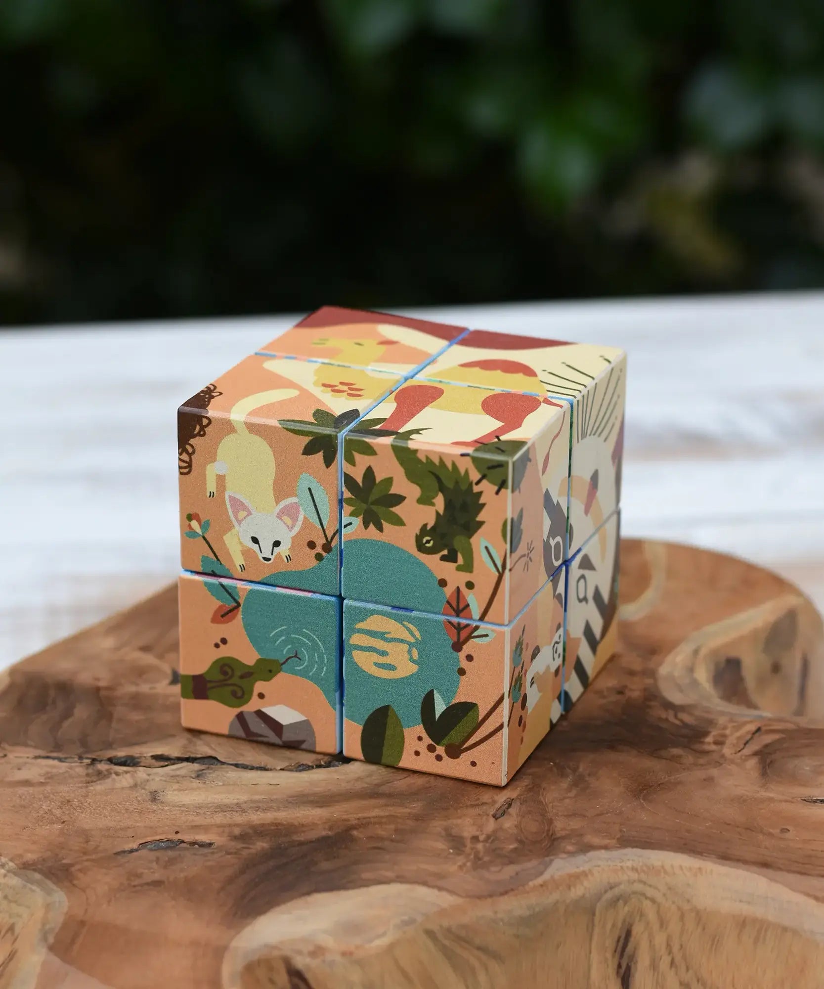 Bajo 2-in-1 reef desert wooden cube block puzzle shown on the desert design side placed on a wooden surface. 
