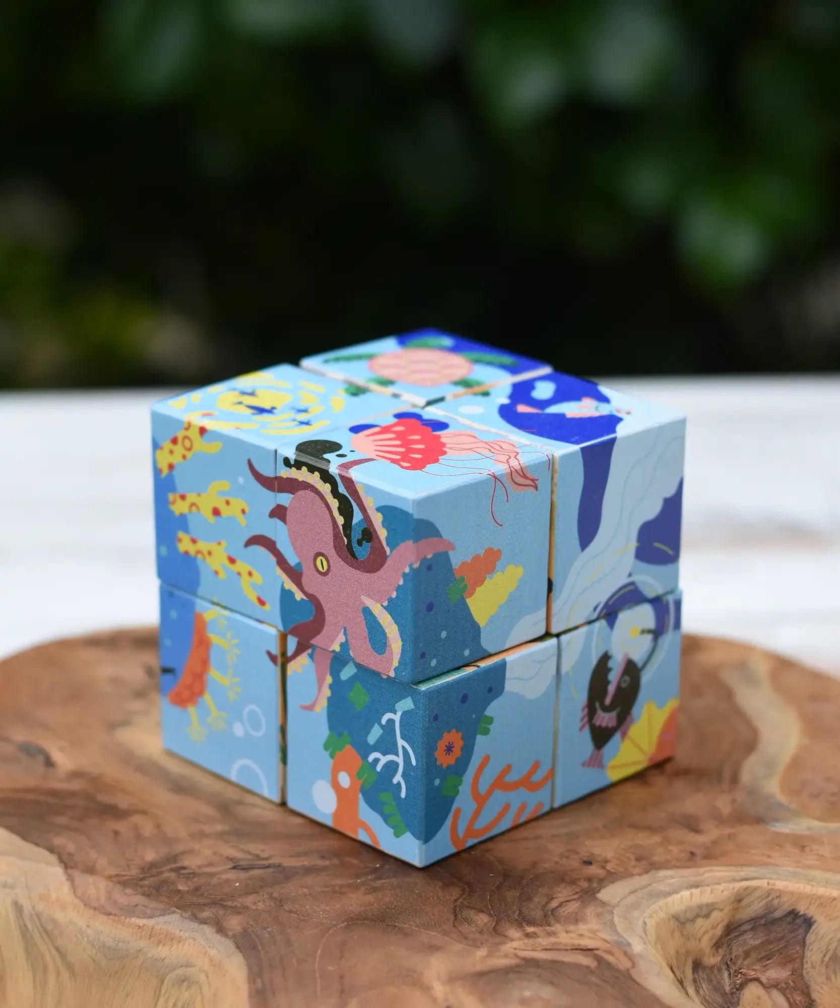 Bajo 2-in-1 reef desert wooden cube block puzzle shown on the reef design side with an octopus, coral, fish and other sea creatures.