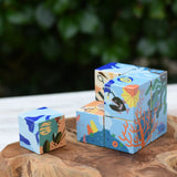 Bajo 2-in-1 reef desert wooden cube block puzzle shown on the reef design side with one block taken out of the cube.