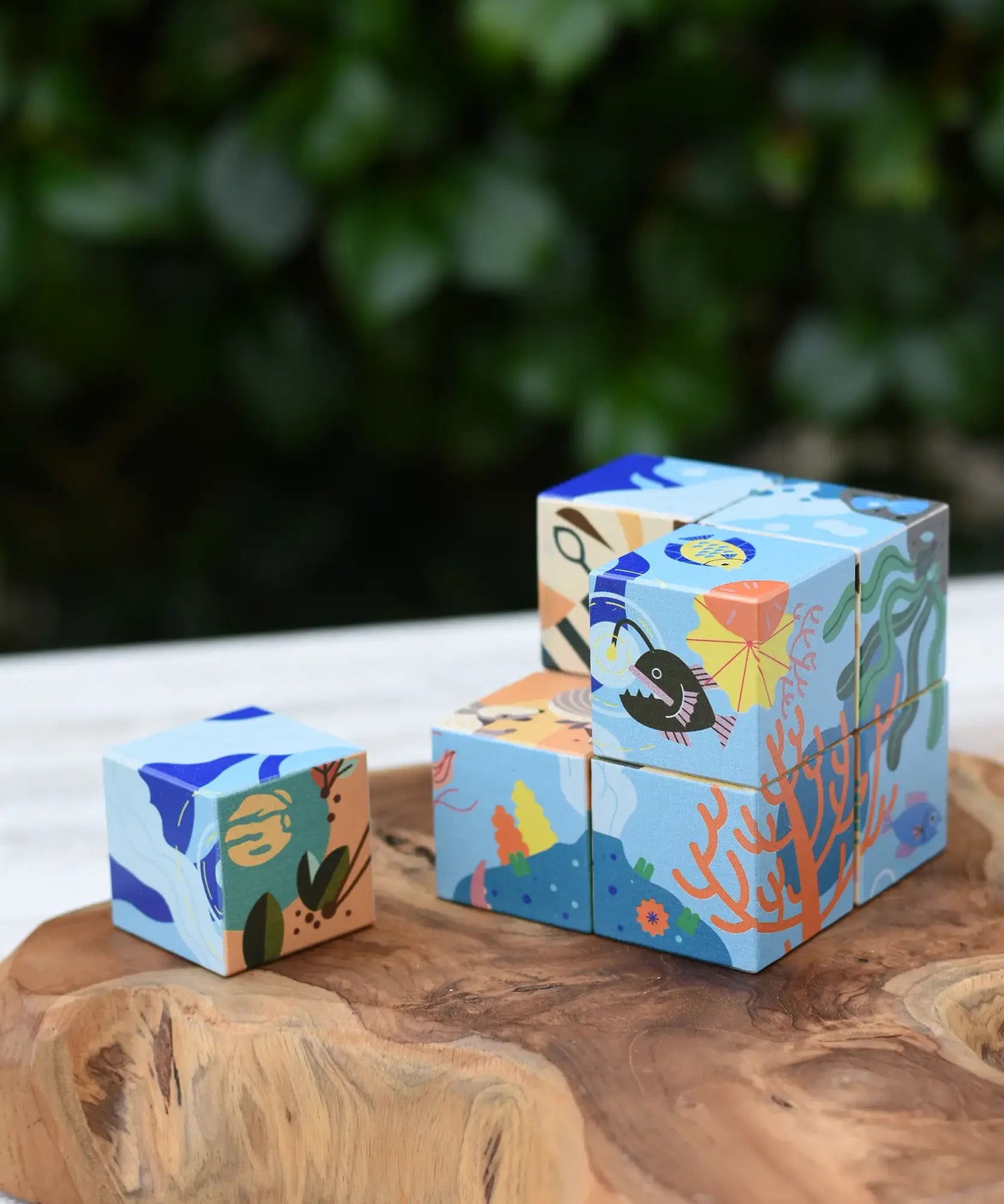 Bajo 2-in-1 reef desert wooden cube block puzzle shown on the reef design side with one block taken out of the cube.