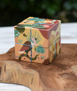 Bajo 2-in-1 reef desert wooden cube block puzzle shown on the desert design side placed on a wooden surface. 