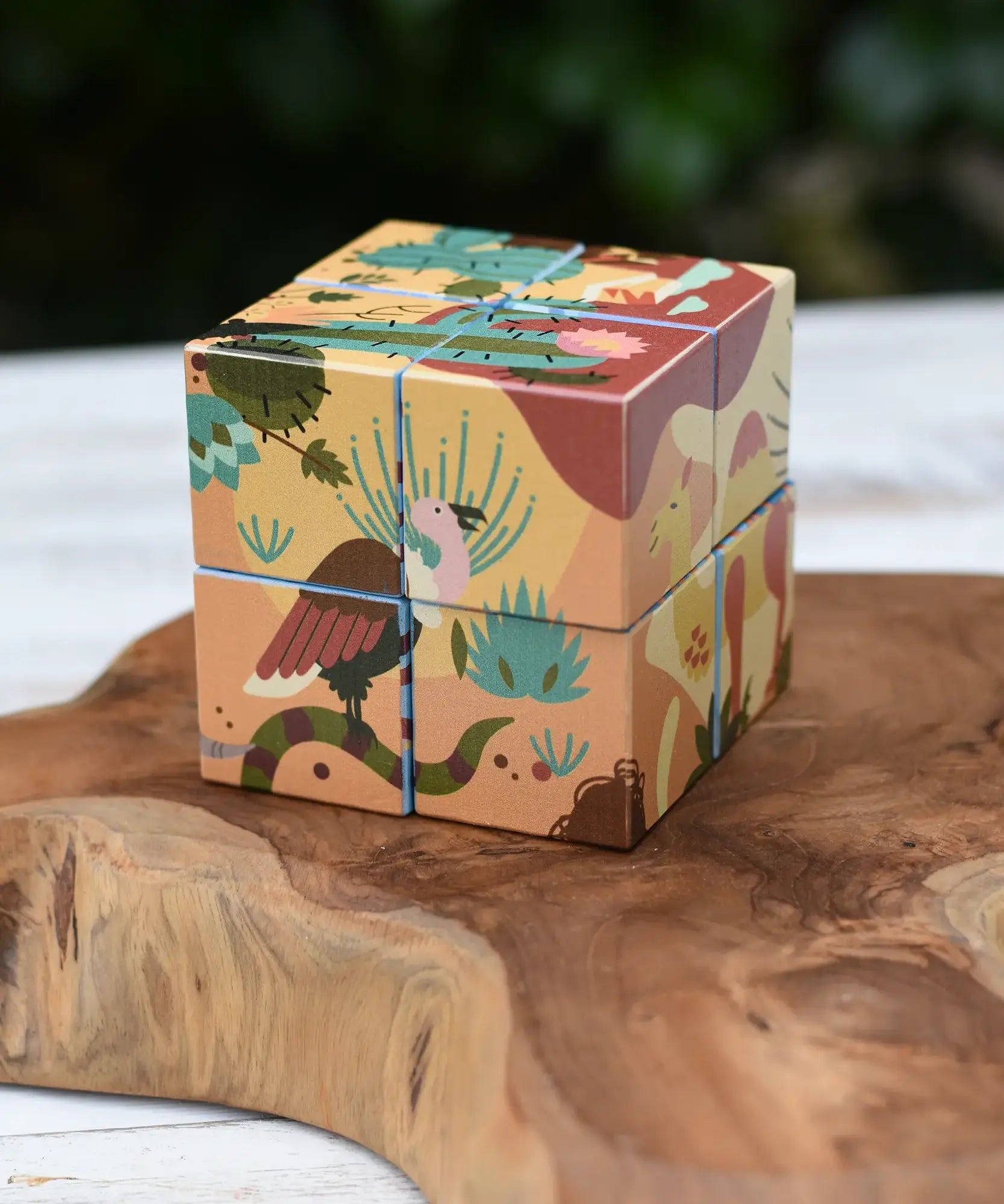 Bajo 2-in-1 reef desert wooden cube block puzzle shown on the desert design side placed on a wooden surface. 