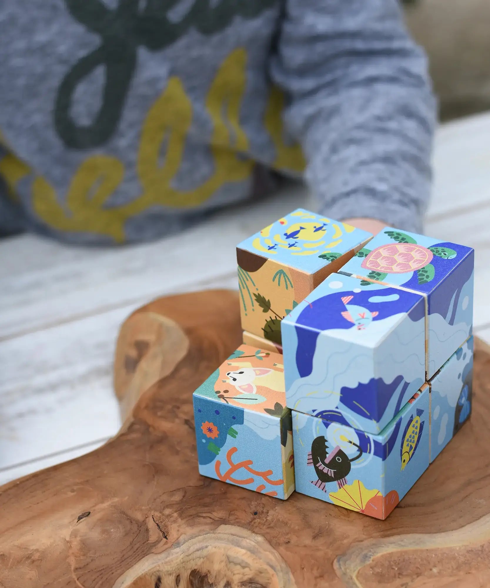 Close up of the Bajo 2-in-1 reef desert wooden cube block puzzle shown on the reef design side with one of the blocks taken away from the cube.